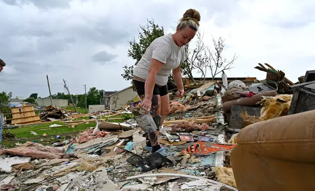 Angela Lewis goes through the remains of a house that was destroyed by severe weather in the Sunshine Hills neighborhood in London, Ky., Monday, May 19, 2025. (AP Photo/Timothy D. Easley)