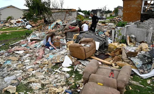 Volunteers help go through the remains of a home looking for what they could salvage in the Sunshine Hills neighborhood in London, Ky., Monday, May 19, 2025. (AP Photo/Timothy D. Easley)