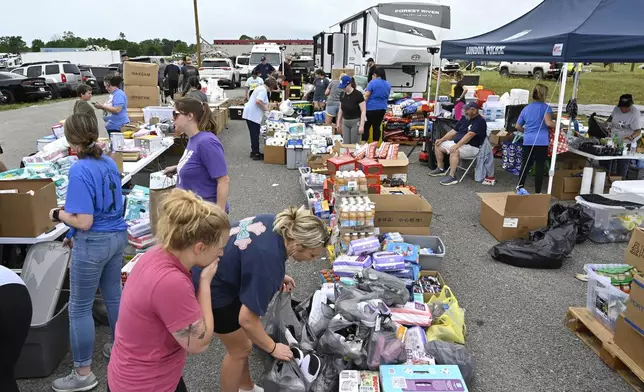 Volunteers sort food and clothing for distribution at the command center at the London-Corbin Airport in London, Ky., Monday, May 19, 2025. (AP Photo/Timothy D. Easley)