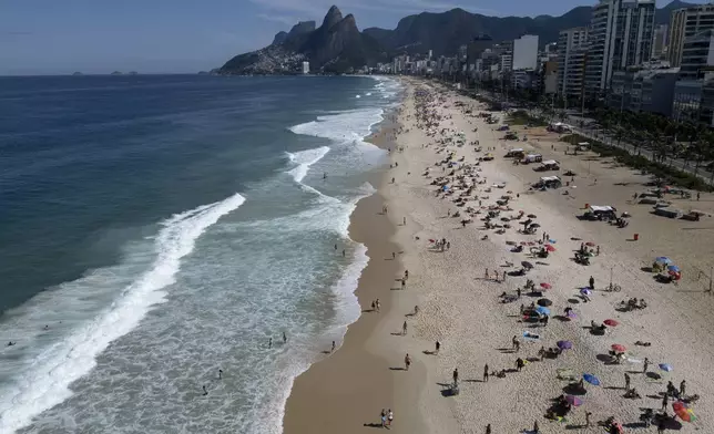 Beachgoers gather on the Ipanema Beach boardwalk in Rio de Janeiro, Sunday, May 25, 2025. (AP Photo/Bruna Prado)