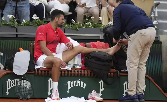 Serbia's Novak Djokovic receives medical assistance during his second round match of the French Tennis Open against France's Corentin Moutet, at the Roland-Garros stadium, in Paris, Thursday, May 29, 2025. (AP Photo/Christophe Ena)