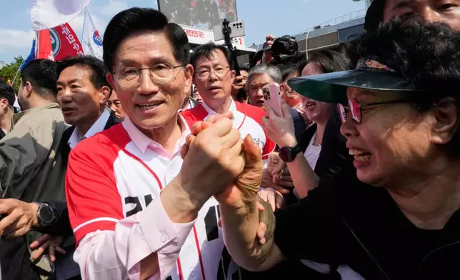South Korea's People Power Party's presidential candidate Kim Moon Soo is greeted by a woman during a presidential election campaign in Seoul, South Korea, Tuesday, May 20, 2025. (AP Photo/Ahn Young-joon)