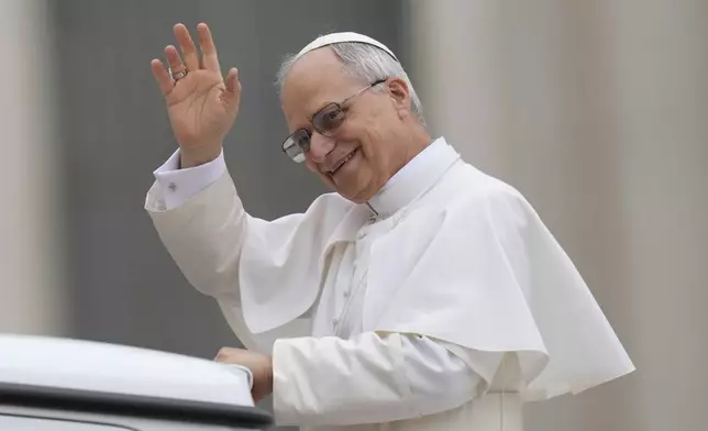 Pope Leo XIV waves as he arrives for his first weekly general audience in St. Peter's Square at The Vatican, Wednesday, May 21, 2025. (AP Photo/Gregorio Borgia)