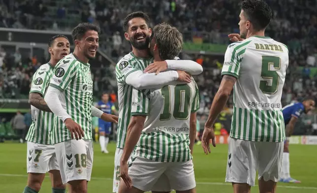 Real Betis players celebrate after Betis' Abde Ezzalzouli, centre, scored his side's opening goal during the Europa Conference League final soccer match between Real Betis and Chelsea in Wroclaw, Poland, Wednesday, May 28, 2025. (AP Photo/Czarek Sokolowski)