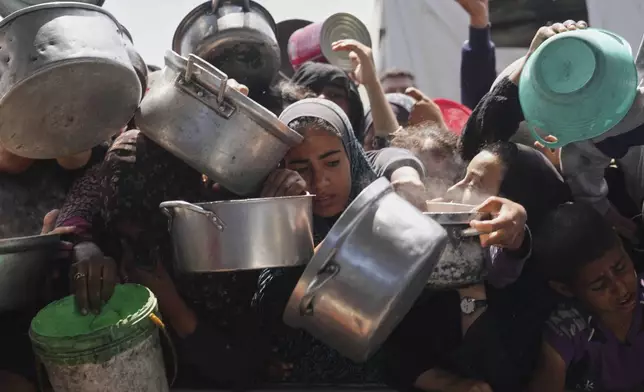 Palestinians struggle to get donated food at a community kitchen in Khan Younis, Gaza Strip, Monday, May 5, 2025. (AP Photo/Abdel Kareem Hana)