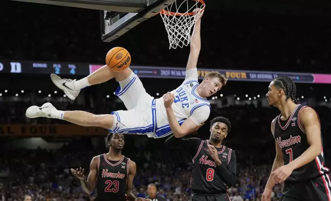 FILE - Duke's Cooper Flagg (2) looks back after dunking the ball as Houston's Terrance Arceneaux (23), Mylik Wilson (8) and Milos Uzan (7) watch during the first half in the national semifinals at the Final Four of the NCAA college basketball tournament, Saturday, April 5, 2025, in San Antonio. (AP Photo/Eric Gay, File)