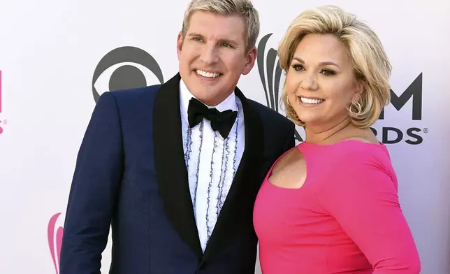 FILE - Julie Chrisley, right, and her husband Todd Chrisley pose for photos at the 52nd annual Academy of Country Music Awards April 2, 2017, in Las Vegas. (Jordan Strauss/Invision/AP, File)