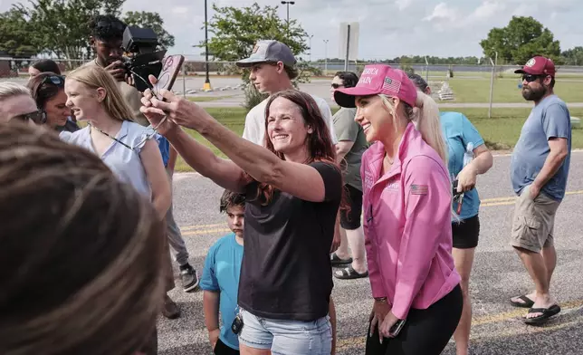 A fan takes a photo with Savannah Chrisley, daughter of reality television star Todd Chrisley, after she spoke outside the Federal Prison Camp, Wednesday, May 28, 2025, in Pensacola, Fla. (AP Photo/Dan Anderson)
