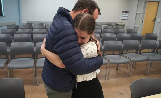 In this image taken from video, Kevin Lyman comforts his daughter, Lizzie, after her team from Atlanta's Midtown High School lost in the semifinals of the National High School Ethics Bowl, Sunday, April 23, 2025, in Chapel Hill, N.C. (AP Photo/Allen G. Breed)