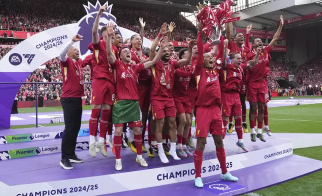 Liverpool players celebrate with the winner's trophy after the English Premier League soccer match between Liverpool and Crystal Palace at the Anfield stadium in Liverpool, England, Sunday, May 25, 2025. (AP Photo/Jon Super)