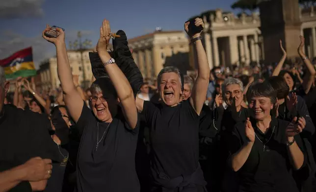 Faithful react after the announcement of the newly elected Pope Leo XIV at the Vatican, Thursday, May 8, 2025. (AP Photo/Francisco Seco)