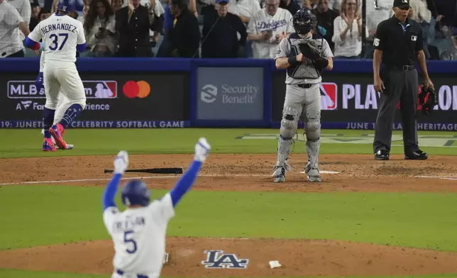 Los Angeles Dodgers' Freddie Freeman, second from left, celebrates after hitting an RBI double, scoring Teoscar Hernández, left, as New York Yankees catcher Austin Wells stands at the plate during the sixth inning of a baseball game Friday, May 30, 2025, in Los Angeles. (AP Photo/Mark J. Terrill)