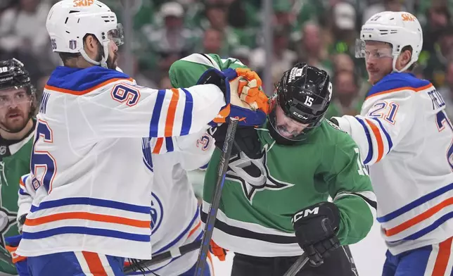 Dallas Stars center Colin Blackwell (15) tussles with Edmonton Oilers defenseman Jake Walman (96) and center Trent Frederic (21) during the first period in Game 2 of the Western Conference finals in the NHL hockey Stanley Cup playoffs Friday, May 23, 2025, in Dallas. (AP Photo/LM Otero)