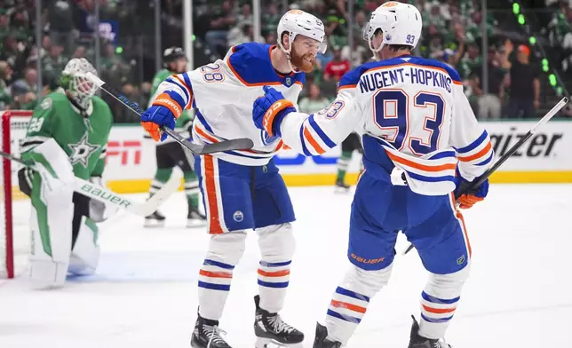 Edmonton Oilers right wing Connor Brown (28) celebrates his goal with teammate center Ryan Nugent-Hopkins (93) against the Dallas Stars during the second period in Game 2 of the Western Conference finals in the NHL hockey Stanley Cup playoffs, Friday, May 23, 2025, in Dallas. (AP Photo/LM Otero)