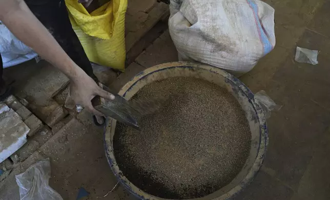 Displaced Palestinians purchase ground lentils as a substitute for making bread due to a shortage of flour in the Gaza Strip, in Khan Younis, on Sunday, May 11, 2025. (AP Photo/Abdel Karem Hanna)
