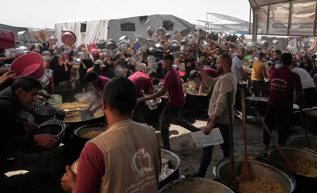 Palestinians struggle to obtain donated food at a community kitchen in Khan Younis, in the southern Gaza Strip, Friday, May 9, 2025. (AP Photo/Abdel Kareem Hana)