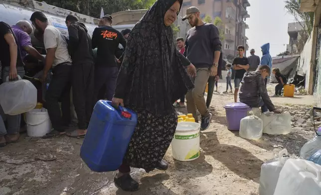 Palestinians collect water in jerrycans at a distribution point west of Gaza City, Sunday, May 11, 2025. (AP Photo/Jehad Alshrafi)