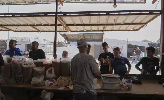 Displaced Palestinians purchase ground lentils as a substitute for making bread due to a shortage of flour in the Gaza Strip, in Khan Younis, on Sunday, May 11, 2025. (AP Photo/Abdel Karem Hanna)