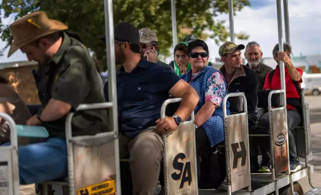 Visitors at the Nampo agricultural fair, one of the largest in the southern hemisphere, ride past the wall of remembrance, a tribute to farmers killed since 1961, near Bothaville, South Africa, May 15, 2025. (AP Photo/Jerome Delay)