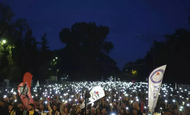 Turkish Cypriot protesters hold the lighted mobile phones aloft as they gather to protest against what they say is Turkey's attempt to erode their secular roots and to strengthen the hold of political Islam over their society, in the northern half of ethnically divided Cyprus' capital Nicosia, on Friday, May 2, 2025. (AP Photo/Petros Karadjias)