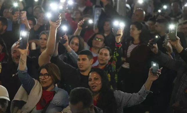 Turkish Cypriot protesters hold the lighted mobile phones aloft as they gather to protest against what they say is Turkey's attempt to erode their secular roots and to strengthen the hold of political Islam over their society, in the northern half of ethnically divided Cyprus' capital Nicosia, on Friday, May 2, 2025. (AP Photo/Petros Karadjias)