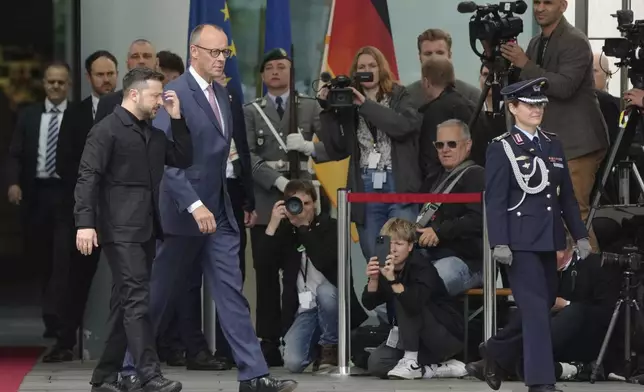 Germany's Chancellor Friedrich Merz, background, welcomes Ukraine's President Volodymyr Zelenskyy during an official military reception at the chancellery in Berlin, Germany, Wednesday, May 28, 2025.(AP Photo/Markus Schreiber)