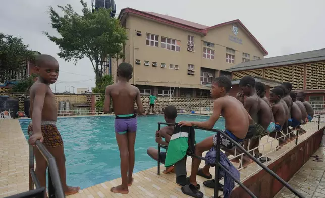Students of the Pacelli School for the Blind and Partially Sighted wait for the start of their swimming lesson at their schools' pool by swimming coach Emeka Chuks Nnadi as part of his Swim in 1 Day, or SID, nonprofit, in Lagos, Nigeria, Wednesday, March 26, 2025. (AP Photo/Sunday Alamba)