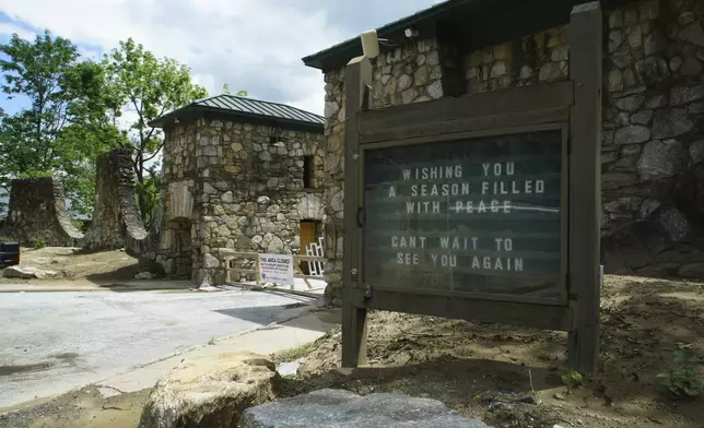 A sign, frozen in time after flooding last fall, stands at the entrance to the closed state park in Chimney Rock Village, N.C., on Wednesday, May 14, 2025. (AP Photo/Allen G. Breed)