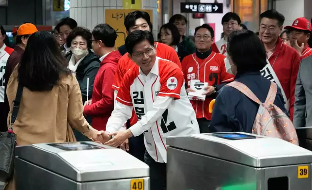 South Korea's People Power Party's presidential election candidate Kim Moon Soo, center, greets people during a presidential election campaign at a subway station in Seoul, South Korea, Thursday, May 15, 2025. (AP Photo/Ahn Young-joon)