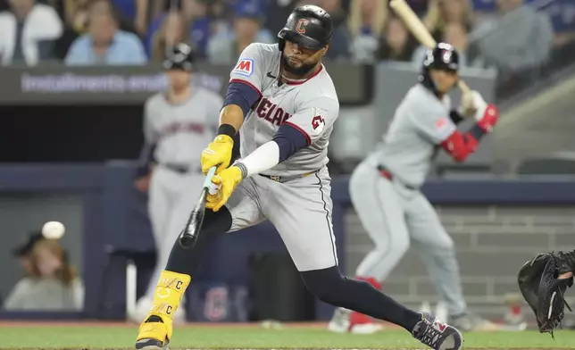 Cleveland Guardians' Carlos Santana hits an RBI single during the sixth inning of a baseball game against the Toronto Blue Jays in Toronto on Friday, May 2, 2025. (Chris Young/The Canadian Press via AP)