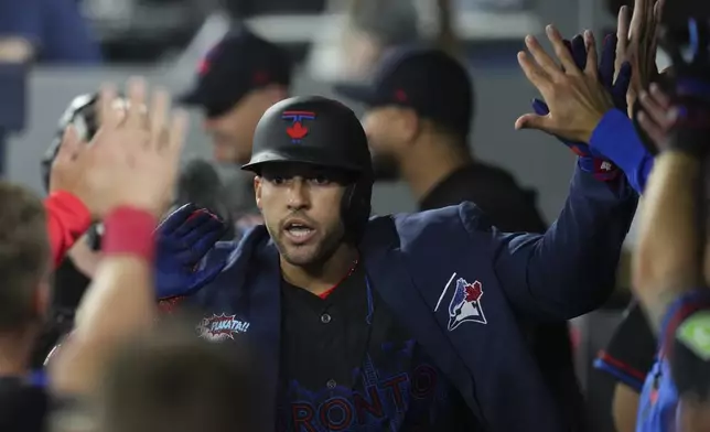 Toronto Blue Jays' George Springer celebrates in the dugout after hitting a home run during the fifth inning of a baseball game against the Cleveland Guardians in Toronto on Friday, May 2, 2025. (Chris Young/The Canadian Press via AP)