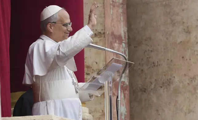 Pope Leo XIV appears at the central balcony of St. Peter's Basilica for his first Sunday blessing after his election, in St. Peter's Square at the Vatican, Sunday May 11, 2025. (AP Photo/Domenico Stinellis)