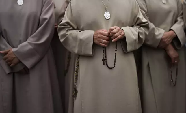 Nuns hold rosaries as Pope Leo XIV appears at the central balcony of St. Peter's Basilica for his first Sunday blessing after his election, in St. Peter's Square at the Vatican, Sunday, May 11, 2025.(AP Photo/Bernat Armangue)