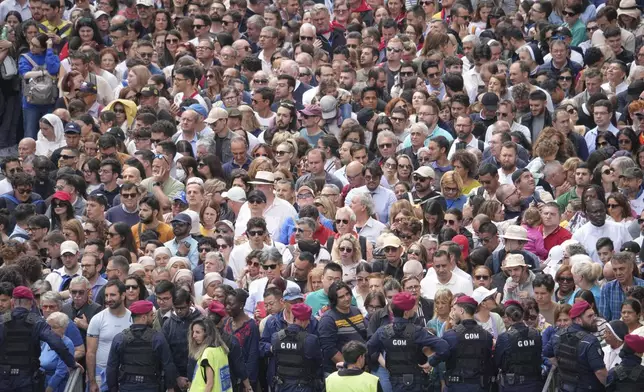 Faithful wait for Pope Leo XIV to appear at the central balcony of St. Peter's Basilica for his first Sunday blessing after his election, in St. Peter's Square at the Vatican, Sunday May 11, 2025. (AP Photo/Alessandra Tarantino)