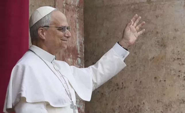 Pope Leo XIV appears at the central balcony of St. Peter's Basilica for his first Sunday blessing after his election, in St. Peter's Square at the Vatican, Sunday May 11, 2025. (AP Photo/Domenico Stinellis)