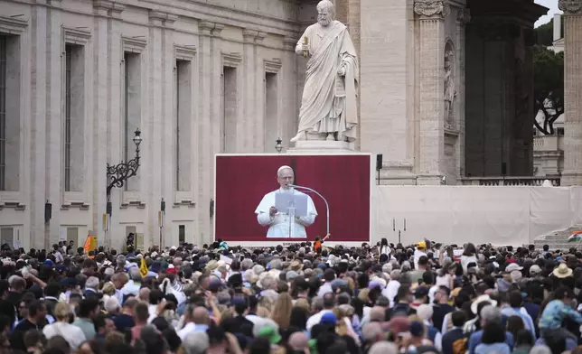 People watch Pope Leo XIV on a giant screen as he delivers his blessing from the central balcony of St. Peter's Basilica for his first Sunday blessing after his election, in St. Peter's Square at the Vatican, Sunday, May 11, 2025.(AP Photo/Andrew Medichini)