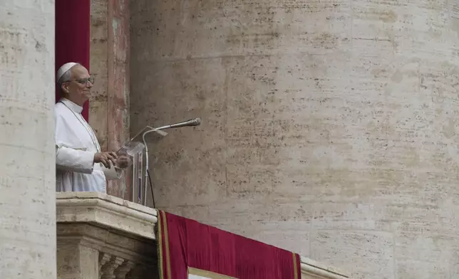 Pope Leo XIV appears at the central balcony of St. Peter's Basilica for his first Sunday blessing after his election, in St. Peter's Square at the Vatican, Sunday May 11, 2025. (AP Photo/Domenico Stinellis)