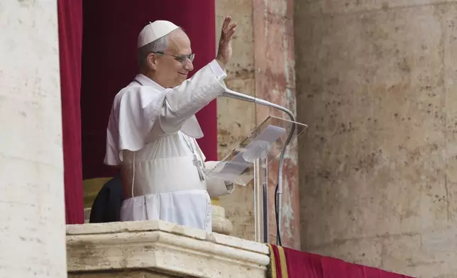 Pope Leo XIV appears at the central balcony of St. Peter's Basilica for his first Sunday blessing after his election, in St. Peter's Square at the Vatican, Sunday May 11, 2025. (AP Photo/Domenico Stinellis)