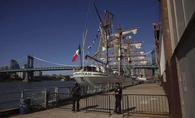 New York Police officers stands watch on Pier 35 where the Cuauhtémoc, a masted Mexican Navy training ship that collided with the Brooklyn Bridge the night before, sits docked. (AP Photo/Yuki Iwamura)