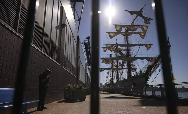 A New York Police officer stands watch on Pier 35 where the Cuauhtémoc, a masted Mexican Navy training ship that collided with the Brooklyn Bridge the night before, sits docked. (AP Photo/Yuki Iwamura)