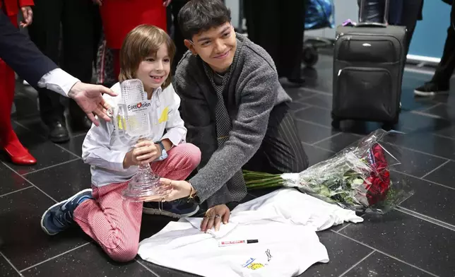 JJ, right, from Austria arrives at the airport in Vienna, Austria, Sunday, May 18, 2025, after winning the Grand Final of the 69th Eurovision Song Contest, in Basel yesterday. (AP Photo/Denes Erdos)