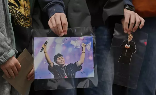 A fan holds photos of JJ from Austria, at the arrival of the singer at the airport in Vienna, Austria, Sunday, May 18, 2025, after JJ wins the Grand Final of the 69th Eurovision Song Contest, in Basel yesterday. (AP Photo/Denes Erdos)