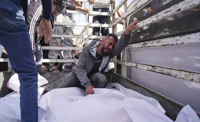 Osama Abu Mosabbah, mourns his wife and two children who were killed in an Israeli army airstrike on the Gaza Strip, during their funeral at Al-Aqsa Hospital in Deir al-Balah, Gaza, Tuesday, May 20, 2025. (AP Photo/Abdel Kareem Hana)