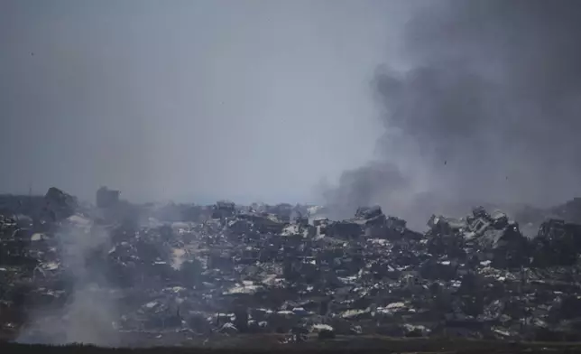 Smoke rises amid buildings that were destroyed during the Israeli ground and air operations in northern of Gaza Strip as seen from southern Israel, Friday, May 23, 2025. (AP Photo/Leo Correa)