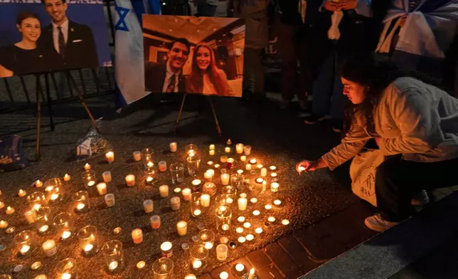 People gather to light candles in a makeshift memorial to honor Yaron Lischinsky and Sarah Milgrim who were killed as they left an event at the Capital Jewish Museum in Washington, during a candlelight vigil outside of the White House in Washington, Thursday, May 22, 2025. (AP Photo/Jose Luis Magana)