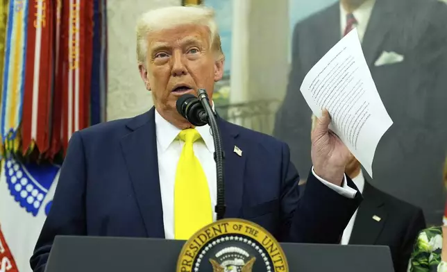 FILE - President Donald Trump holds a document with notes about Kilmar Abrego Garcia as he speaks with reporters in the Oval Office of the White House, April 18, 2025, in Washington.(AP Photo/Alex Brandon, File)