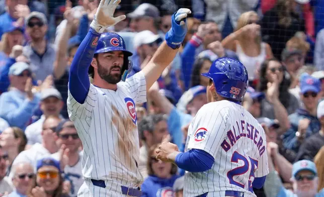 Chicago Cubs' Dansby Swanson, left, and Moisés Ballesteros (25) celebrate after scoring against the Chicago White Sox during the second inning of a baseball game Saturday, May 17, 2025, in Chicago. (AP Photo/David Banks)
