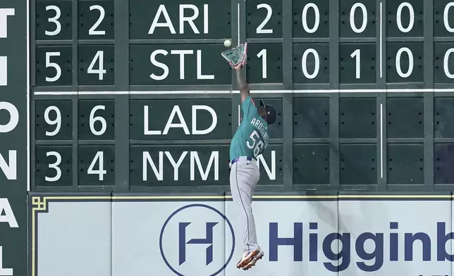 Seattle Mariners left fielder Randy Arozarena attempts to catch a double by Houston Astros' Isaac Paredes during the seventh inning of a baseball game Sunday, May 25, 2025, in Houston. (AP Photo/David J. Phillip)