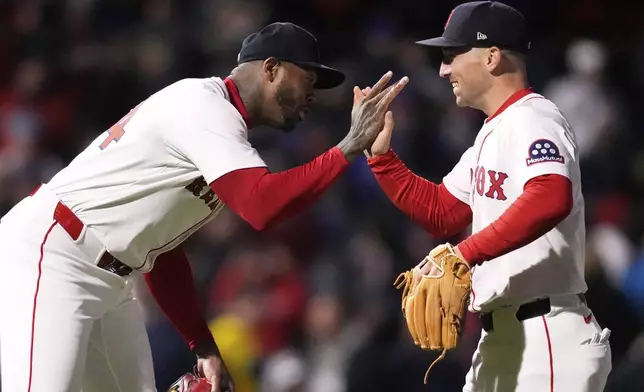 Boston Red Sox pitcher Aroldis Chapman, left, celebrates with Alex Bregman, right, after defeating the New York Mets in a baseball game at Fenway Park, Monday, May 19, 2025, in Boston. (AP Photo/Charles Krupa)