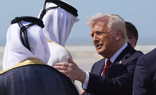 President Donald Trump is greeted by Qatar's Emir Sheikh Tamim bin Hamad Al Thani as he arrives on Air Force One at Hamad International Airport in Doha, Qatar, Wednesday, May 14, 2025. (AP Photo/Alex Brandon)